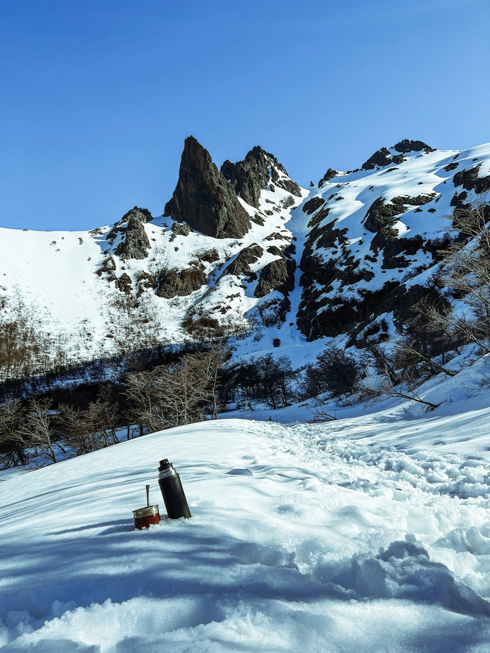 a man standing on top of a snow covered slope