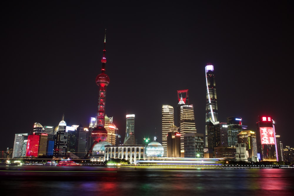 a city skyline at night with lights reflecting off the water