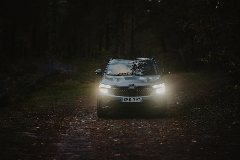 a car driving down a dirt road in the dark