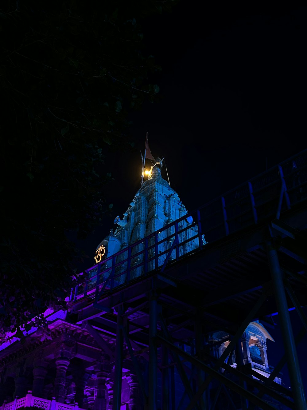 a clock tower lit up at night with purple lighting