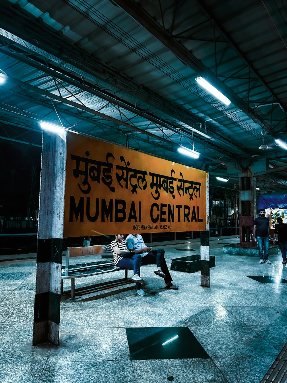 a man sitting on a bench in a train station