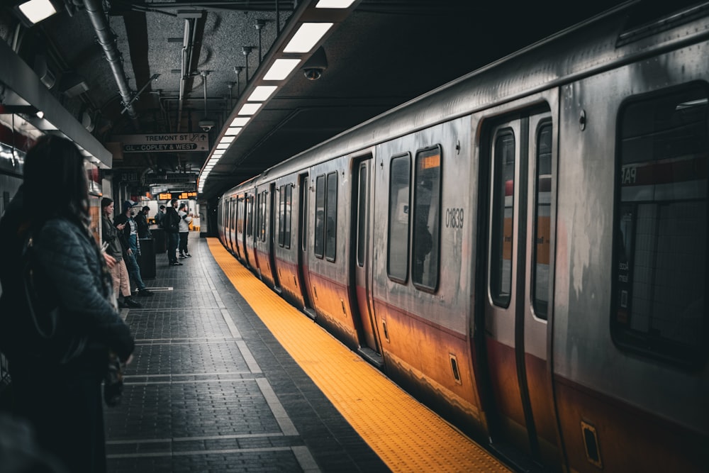 a group of people waiting for a train at a train station