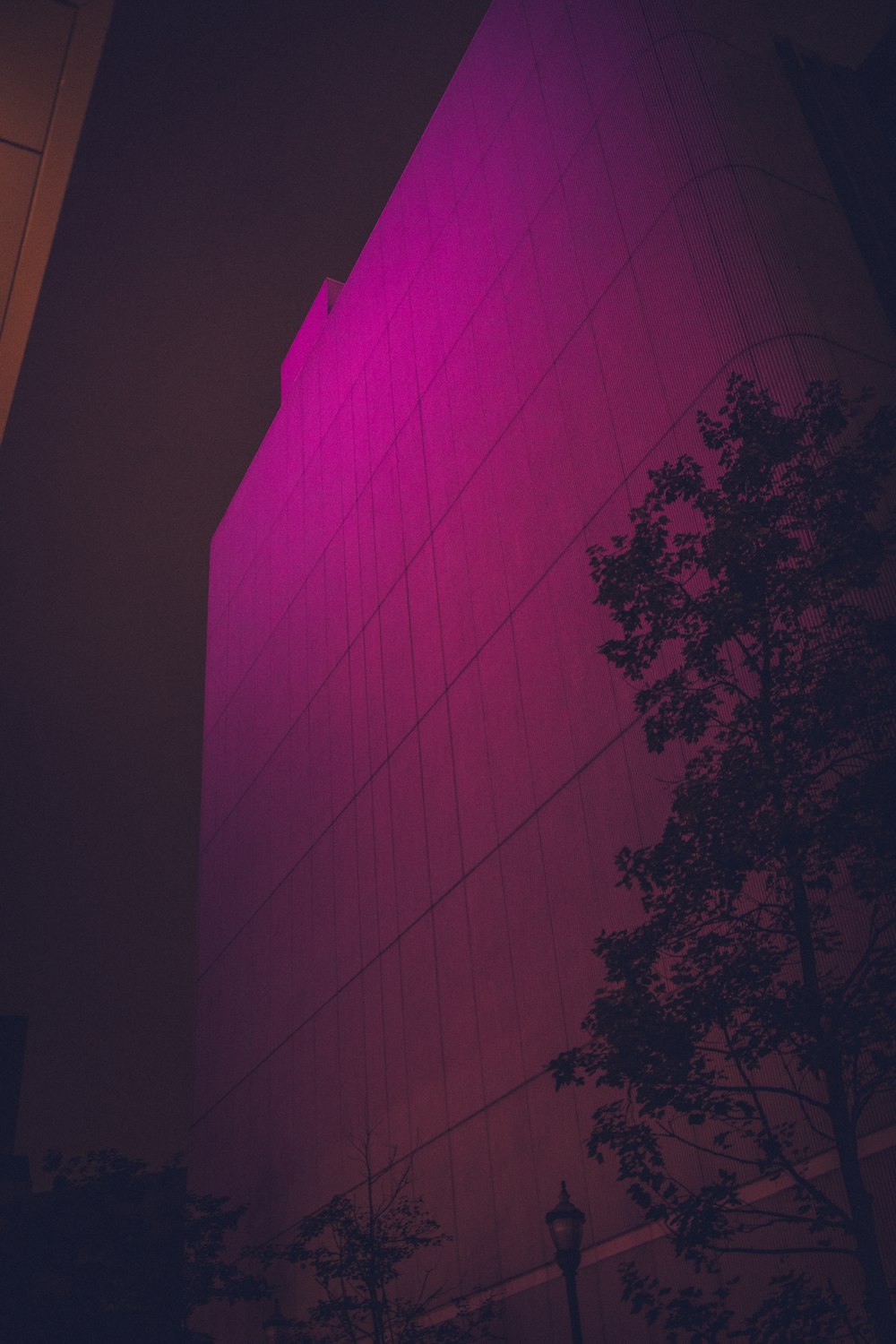 un grand bâtiment avec une lumière violette sur le côté