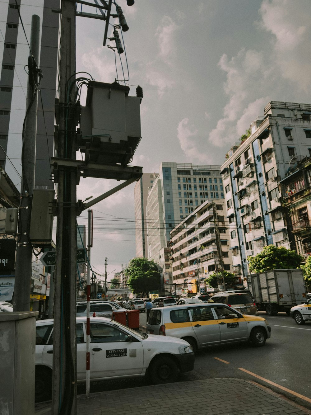 a city street filled with lots of traffic next to tall buildings