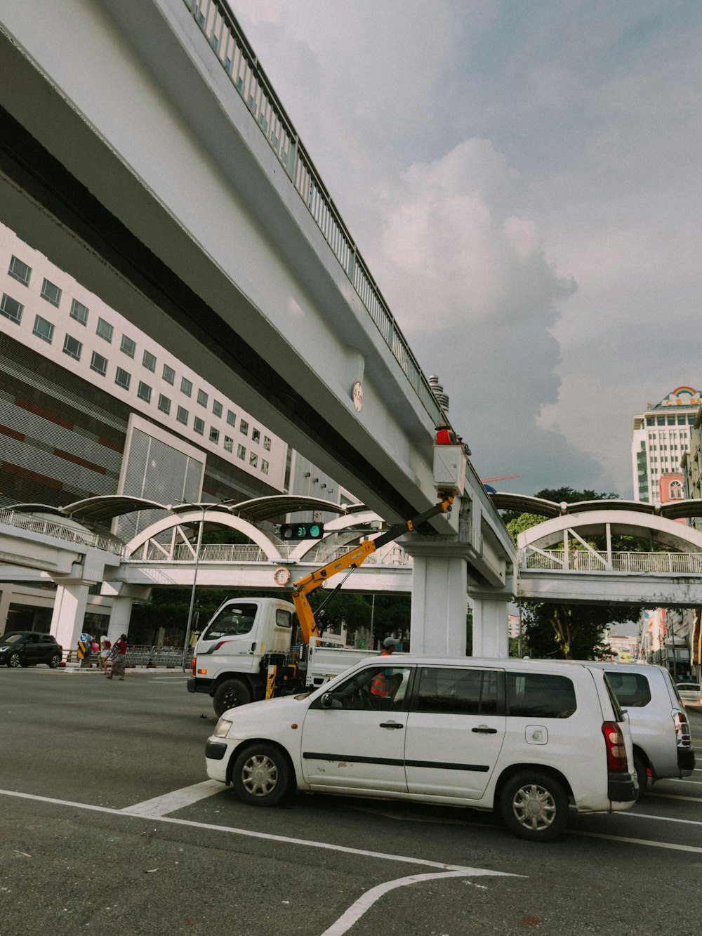 a white van parked in a parking lot next to a bridge