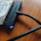 Close-up of a sleek external hard drive with a glowing blue LED indicator on a modern desk.