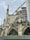 An ornate Gothic-style cathedral with pointed arches and stained glass windows is under renovation. A large construction crane and scaffolding are visible, indicating ongoing restoration work. The sky is overcast, enhancing the dramatic appearance of the architectural details.