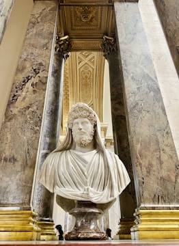 A team brainstorming digital marketing strategies with classical Greek statue busts in the background.