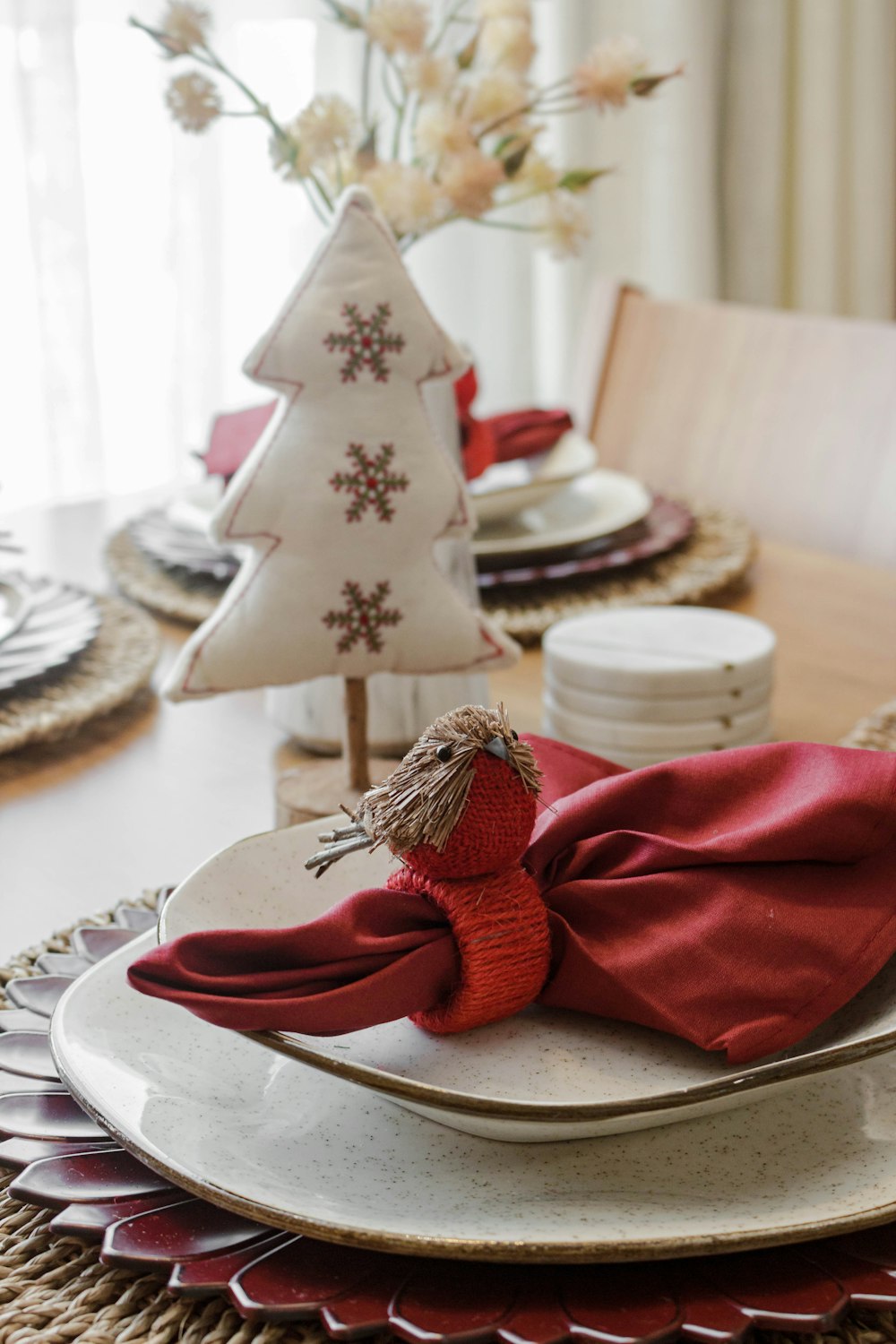 a christmas table setting with red napkins and a christmas tree