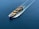 A cargo ship is sailing through a vast expanse of blue water, carrying numerous colorful shipping containers. The ship leaves a trail of waves behind, slicing smoothly through the calm sea.