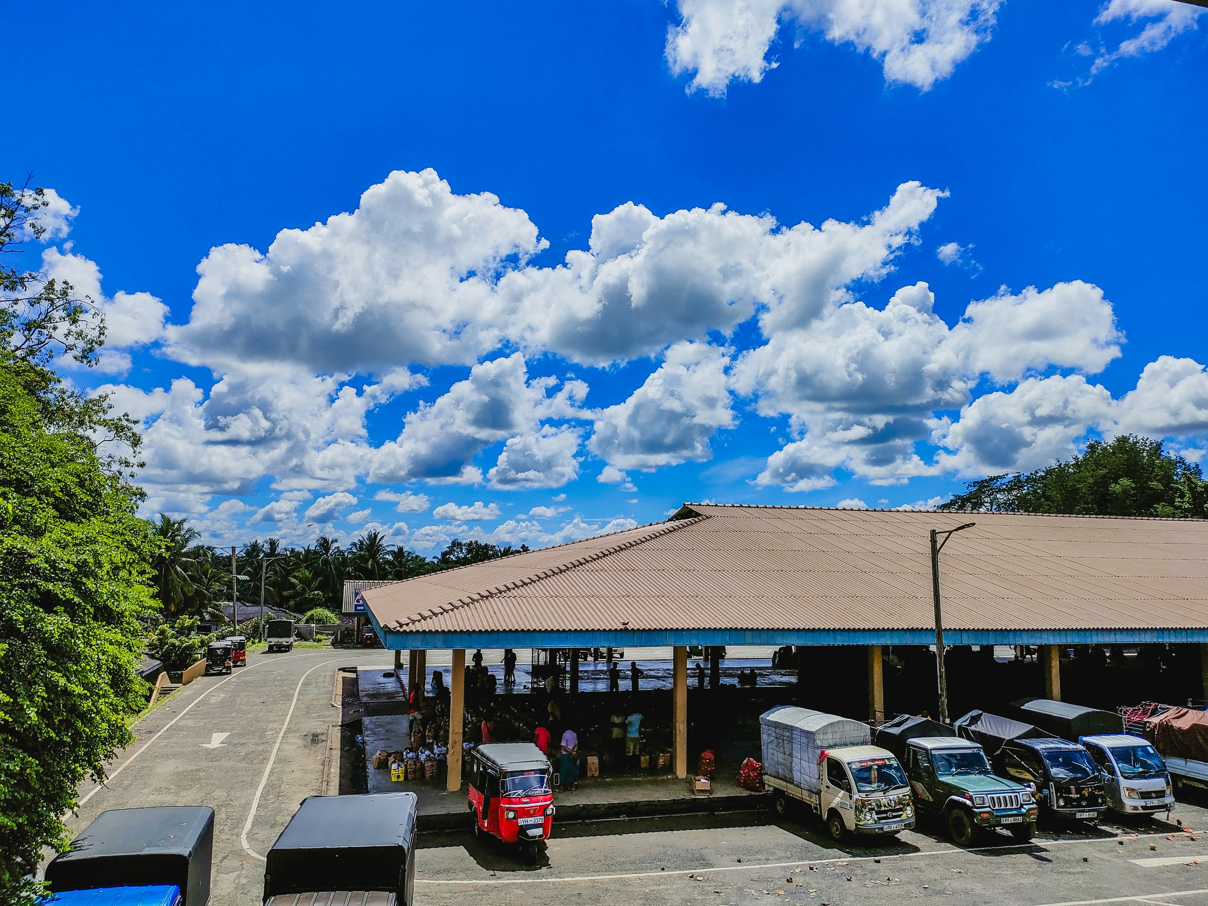 White pyramid shade structure covering commercial parking area with multiple vehicles