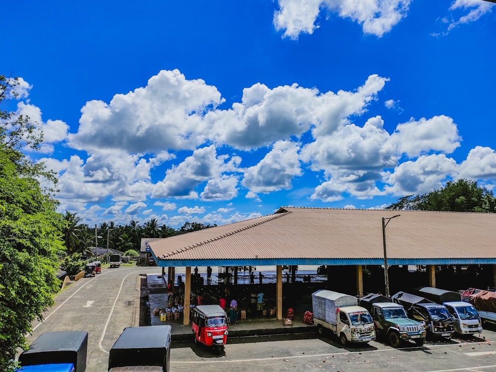 a parking lot filled with lots of cars under a cloudy blue sky
