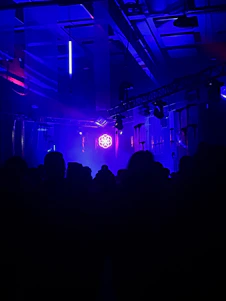 A sleek, dark-themed immersive studio space with purple and gold lighting accents.