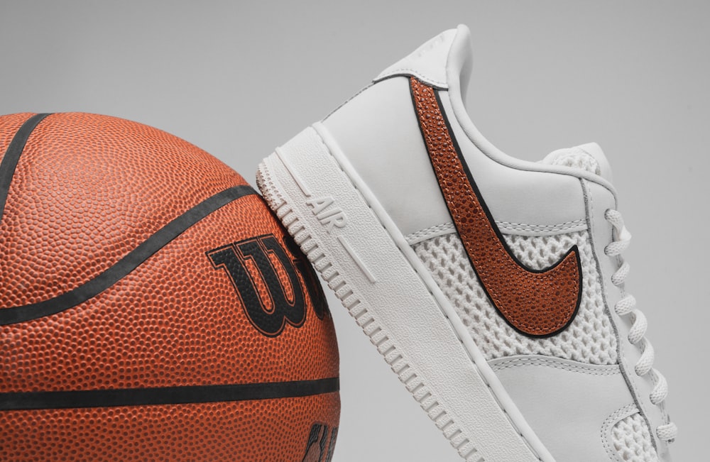 ein Paar Turnschuhe und ein Basketball auf grauem Hintergrund