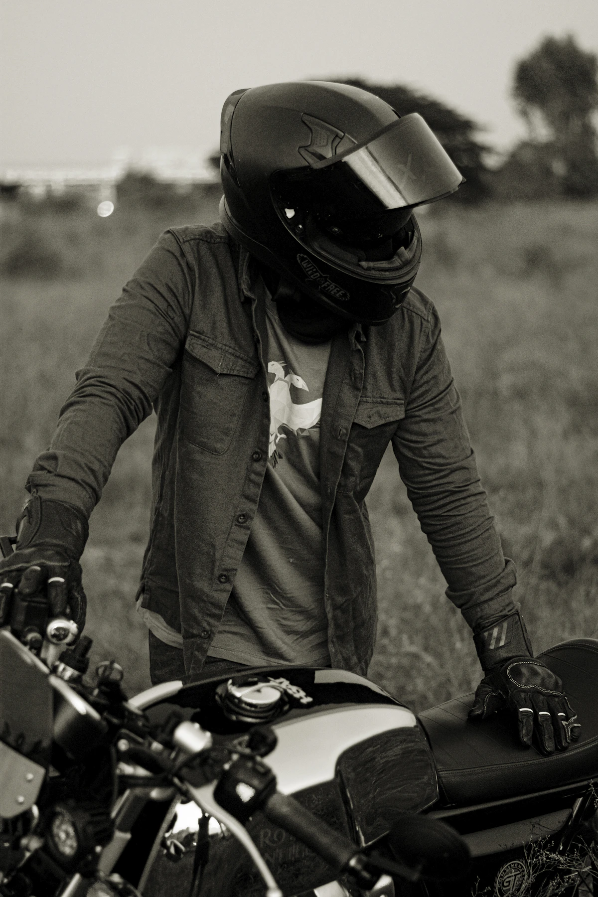 Motoquero con casco y guantes junto a su moto