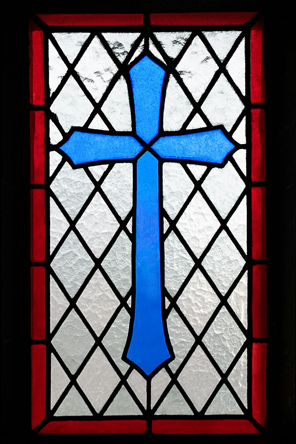 una vidriera con una cruz azul