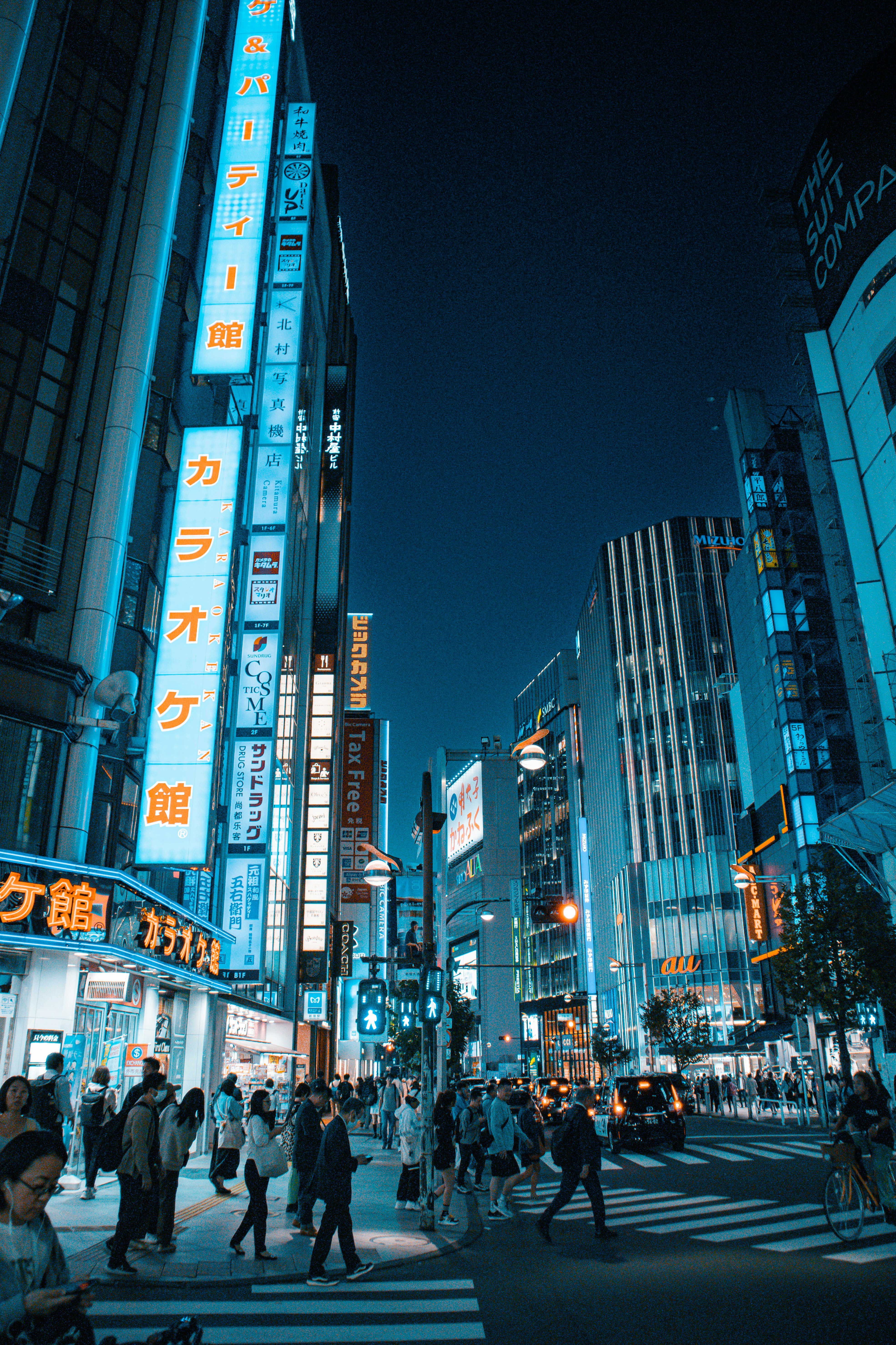 a group of people crossing a street at night
