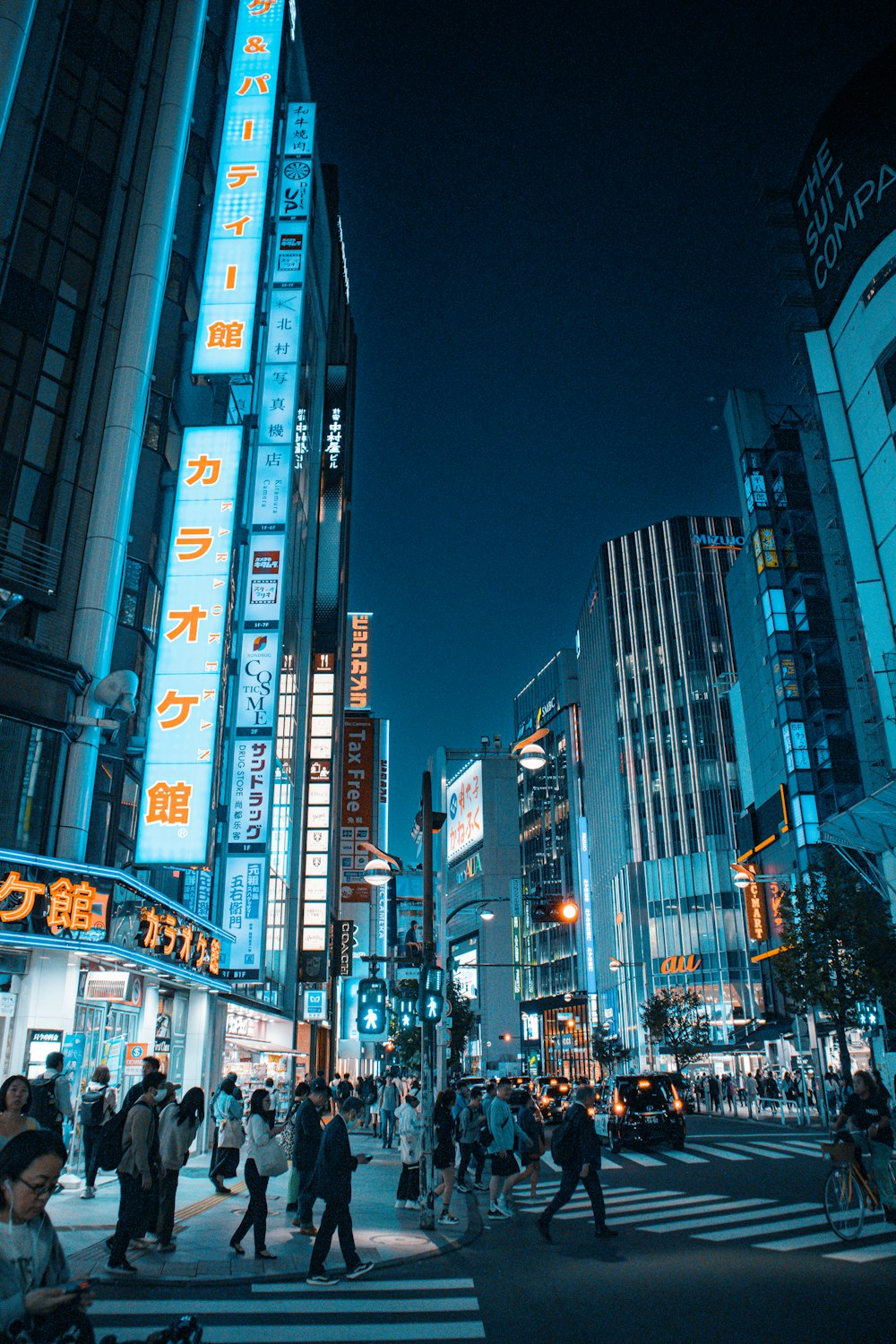 a group of people crossing a street at night