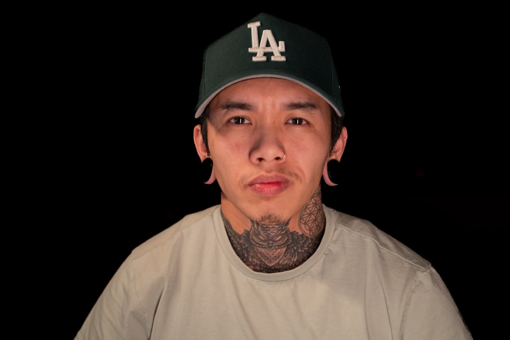 a man with a tattoo on his neck wearing a baseball cap