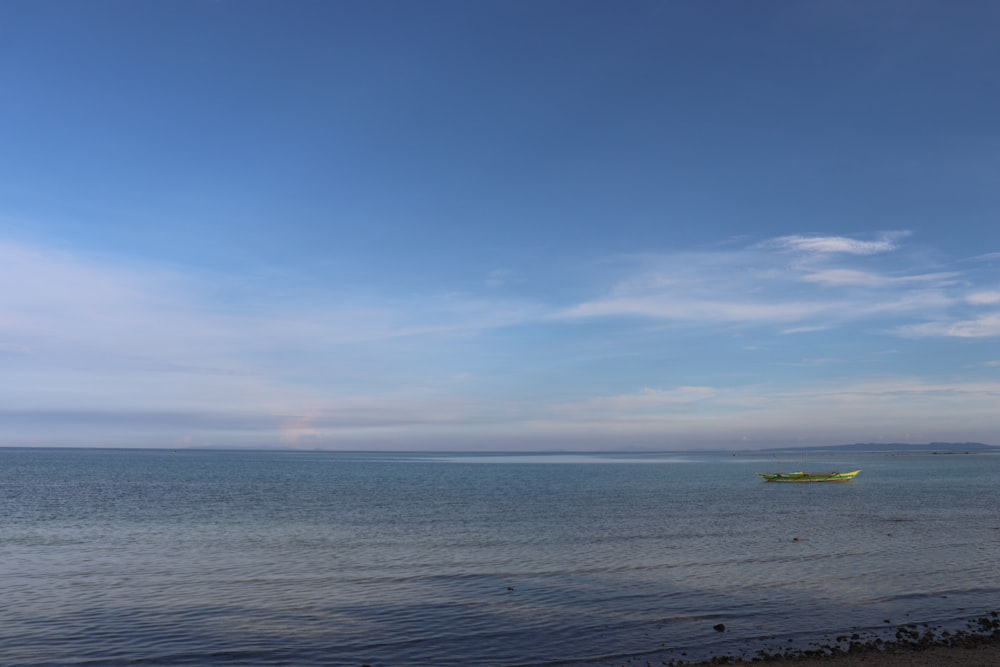 a boat is out on the water under a blue sky