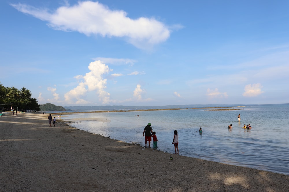 a group of people standing on top of a sandy beach