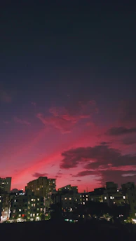 A cloud network diagram glowing over a city skyline at dusk.