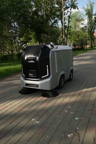 a street sweeper sitting on the side of a brick road