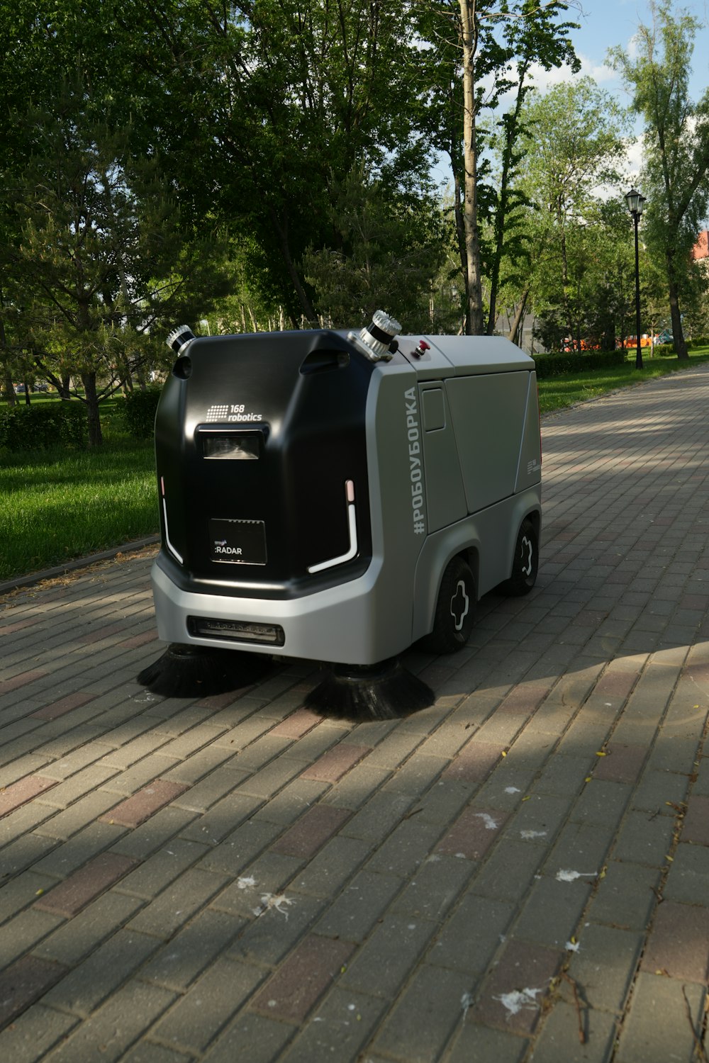 a street sweeper sitting on the side of a brick road