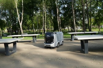an electric vehicle parked in a park next to picnic tables