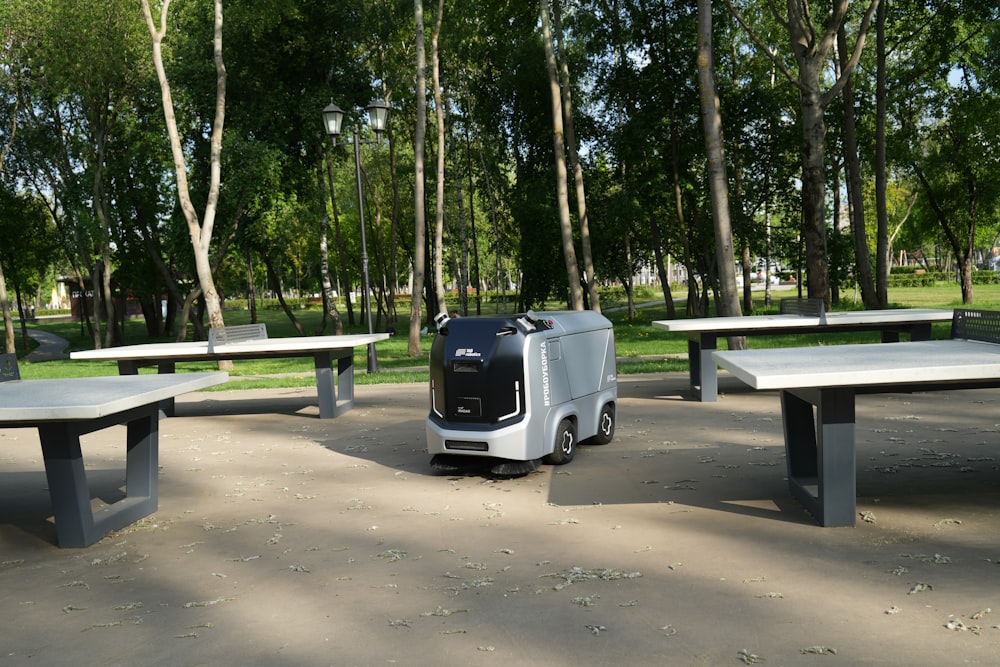 an electric vehicle parked in a park next to picnic tables