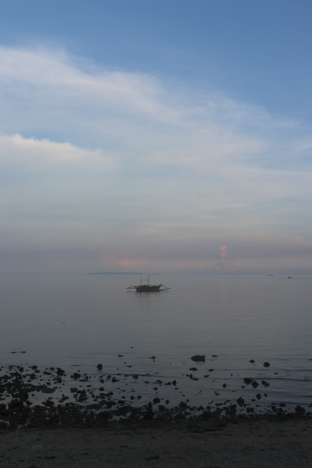 a small boat floating on top of a large body of water