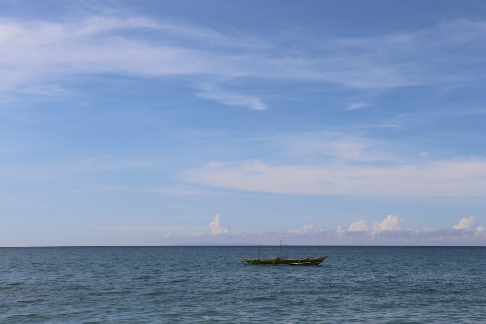 a small boat floating on top of a large body of water