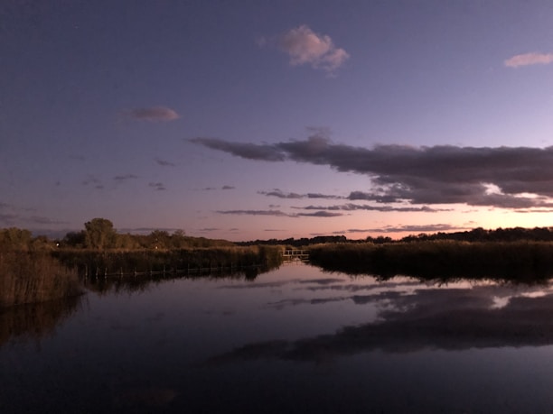 A serene riverside scene at sunset, reflecting the calm and thoughtful mood of Krishna’s storytelling.