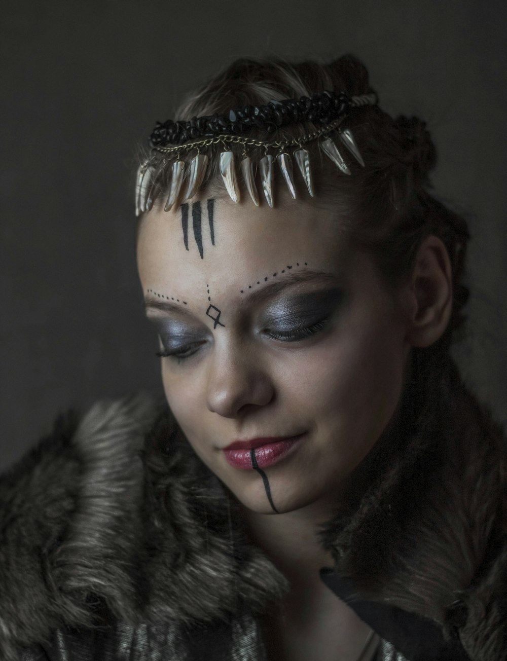 a woman with makeup and feathers on her face