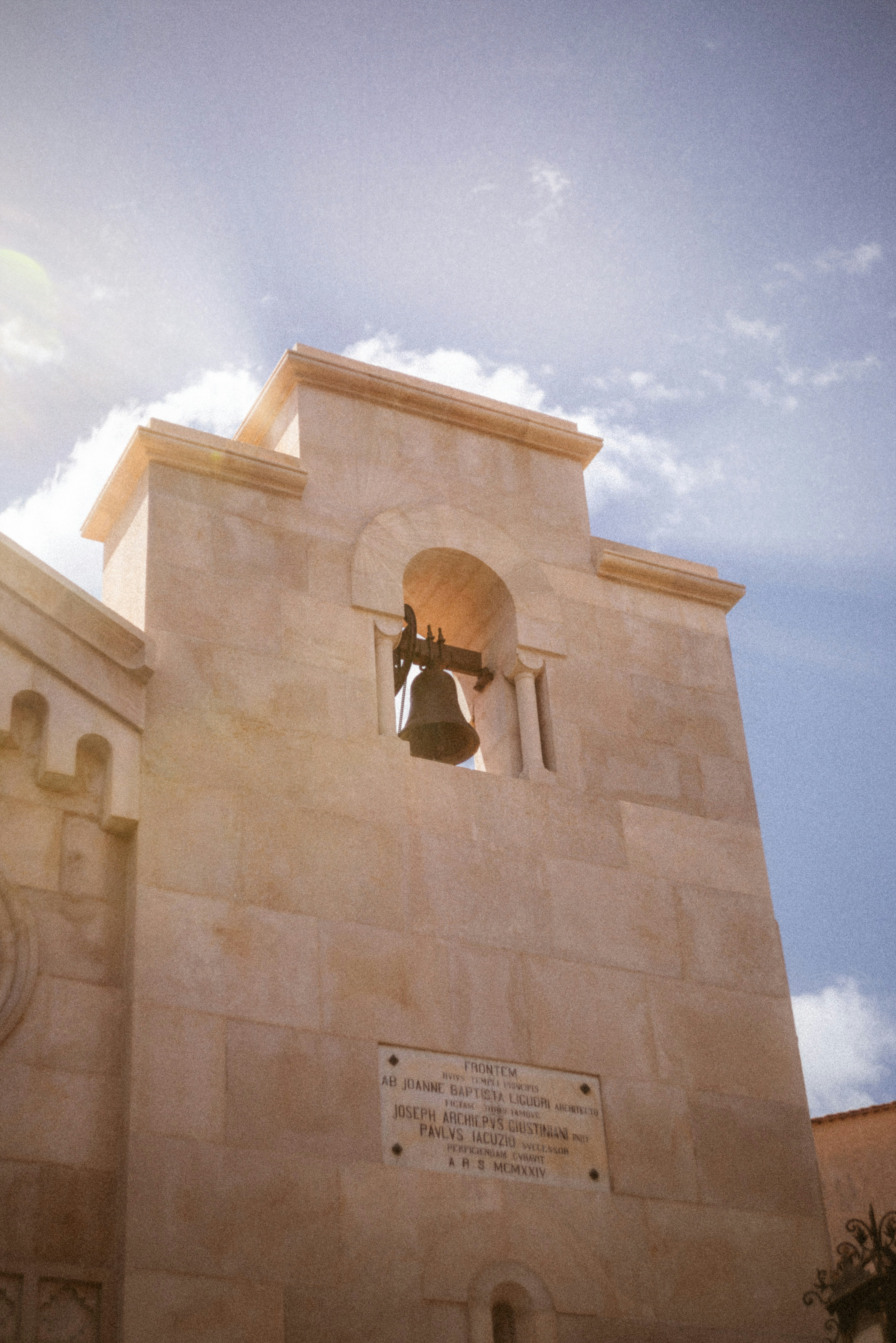 a clock tower with a bell in the middle of it