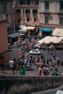 A bustling commercial plaza with storefronts and people enjoying the outdoor space.