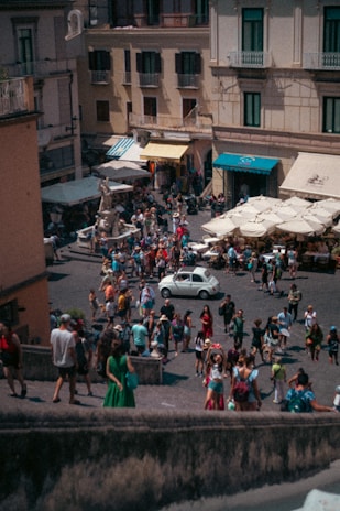 A bustling commercial plaza with storefronts and people enjoying the outdoor space.