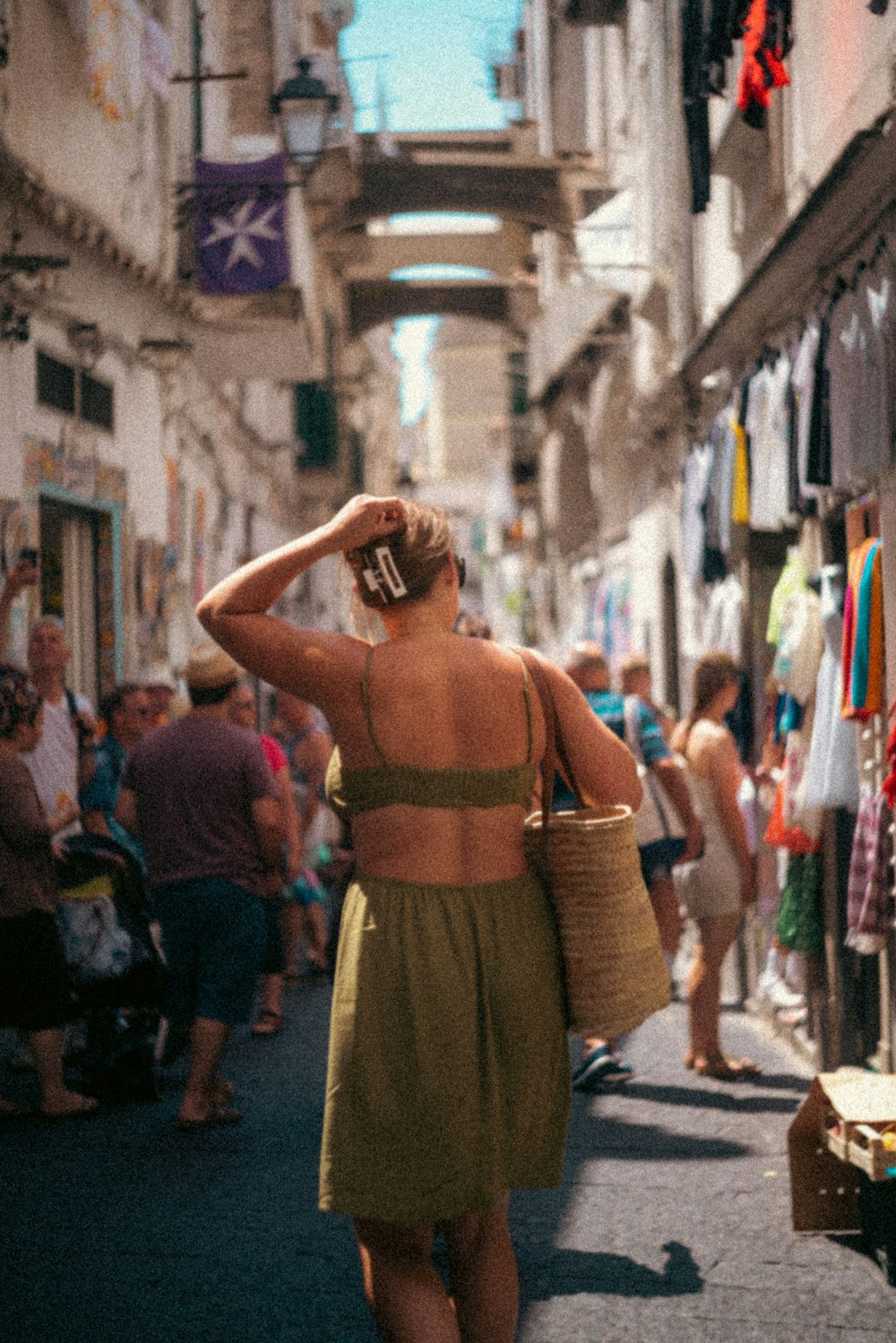 a woman walking down a street next to a crowd of people