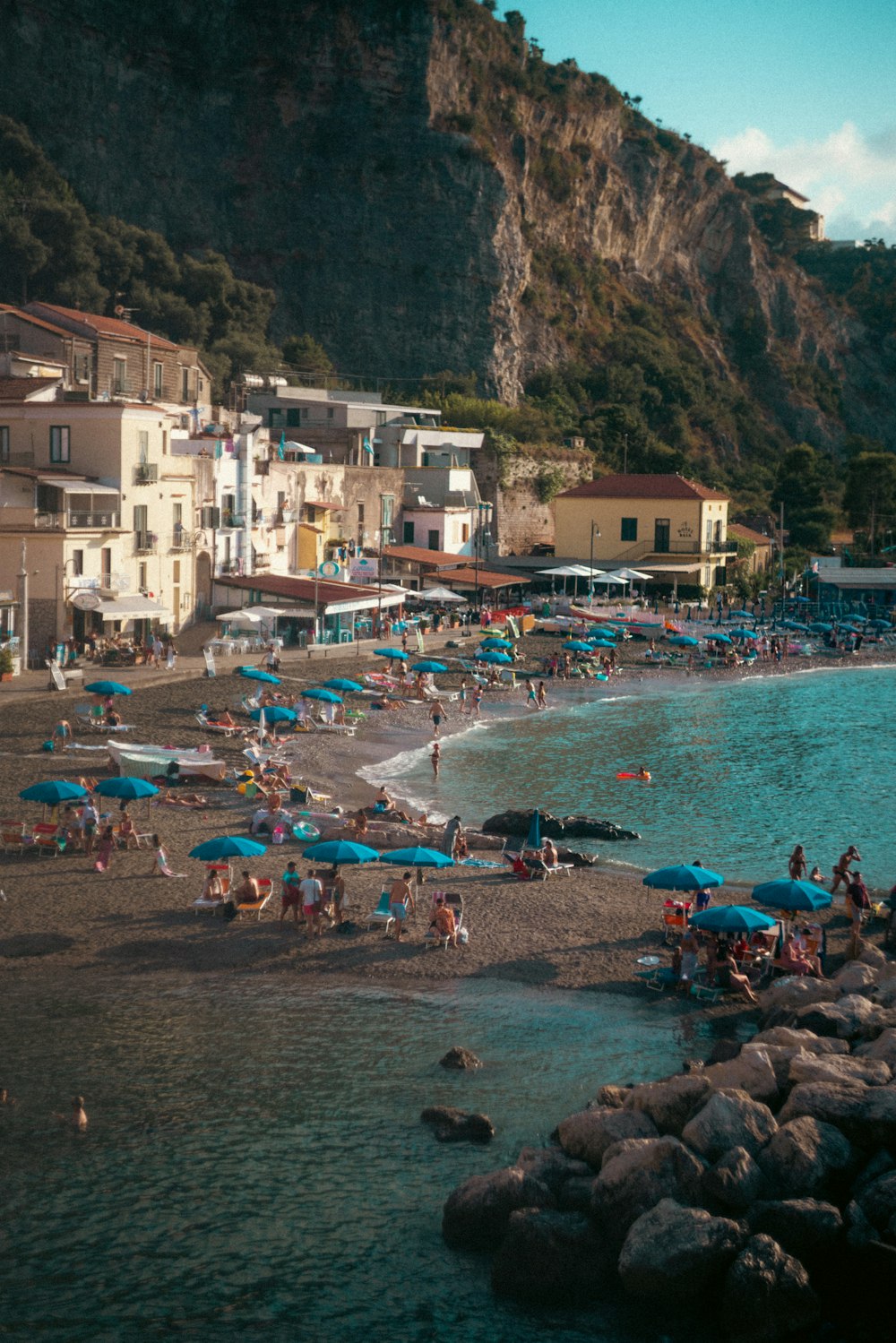 a group of people on a beach with umbrellas