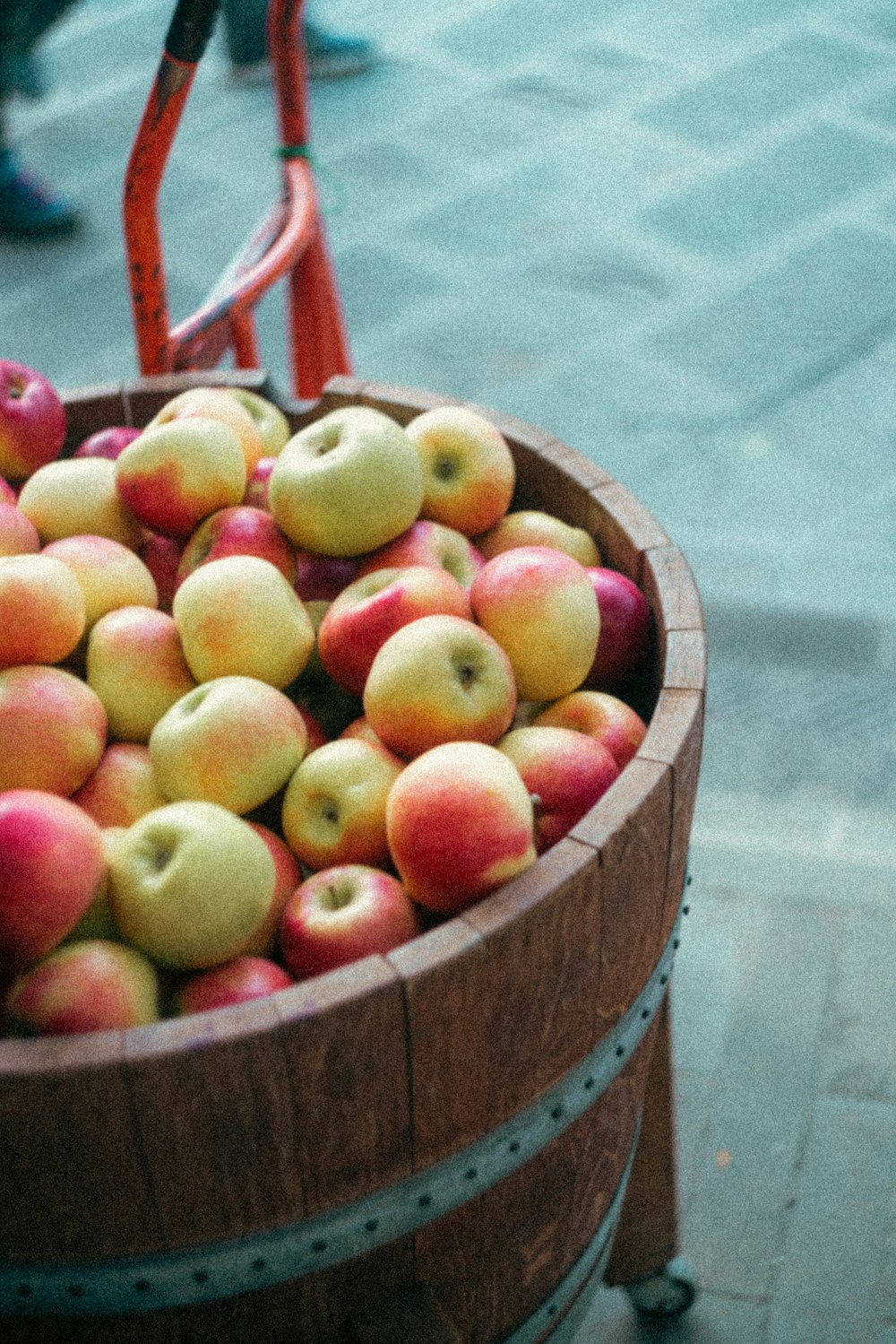 a wooden barrel filled with lots of red and yellow apples