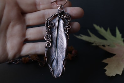 Artisan hands carefully assembling feather earrings with semi-precious stones.