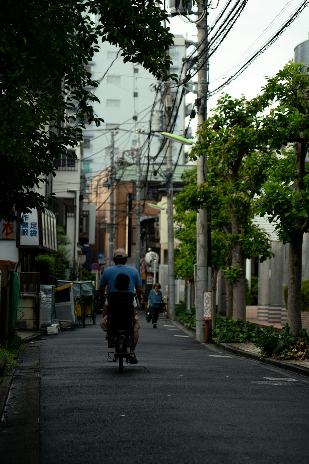 un uomo in sella a una bicicletta lungo una strada accanto a edifici alti