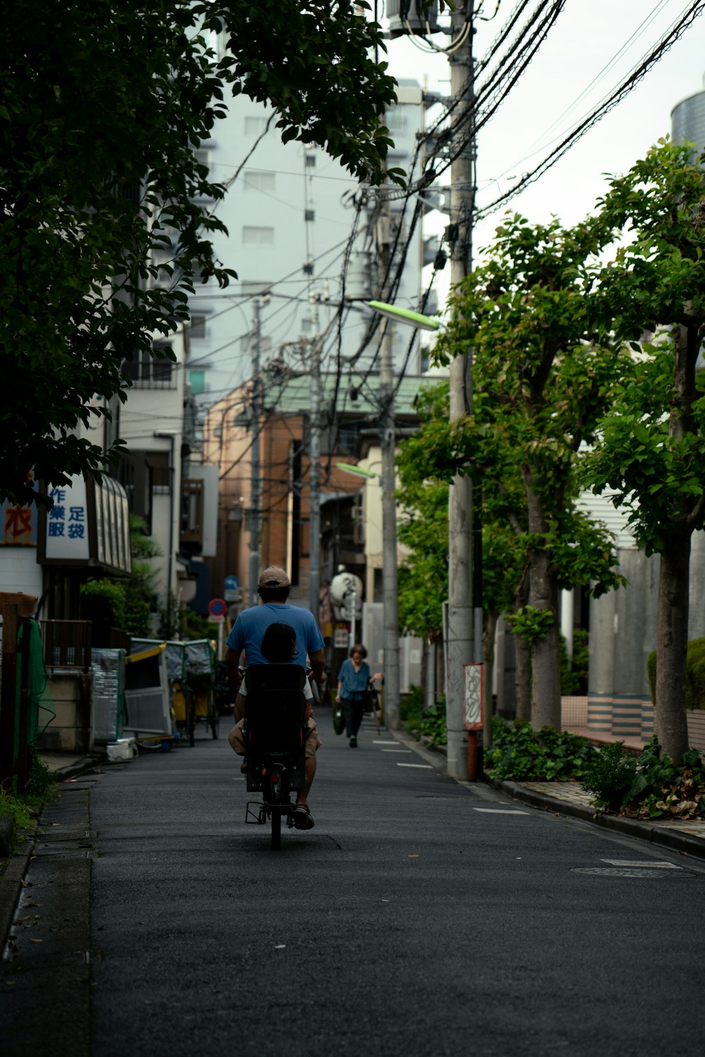 a man riding a bike down a street next to tall buildings