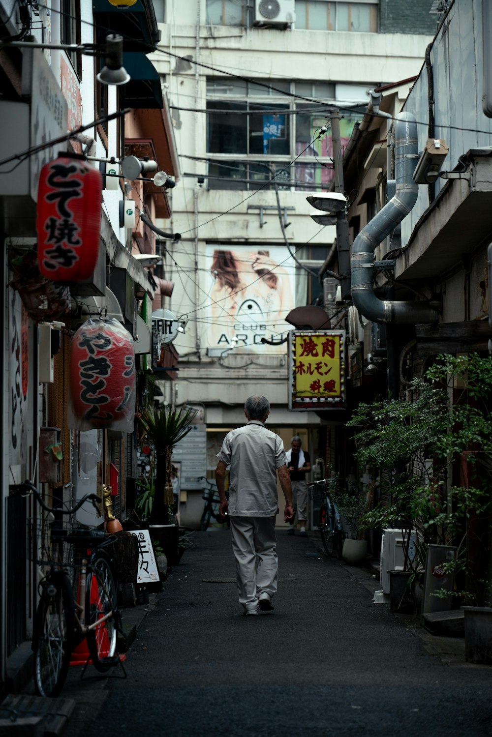 a man walking down a narrow alley way