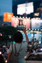 A person scanning a QR code in a bustling urban environment.