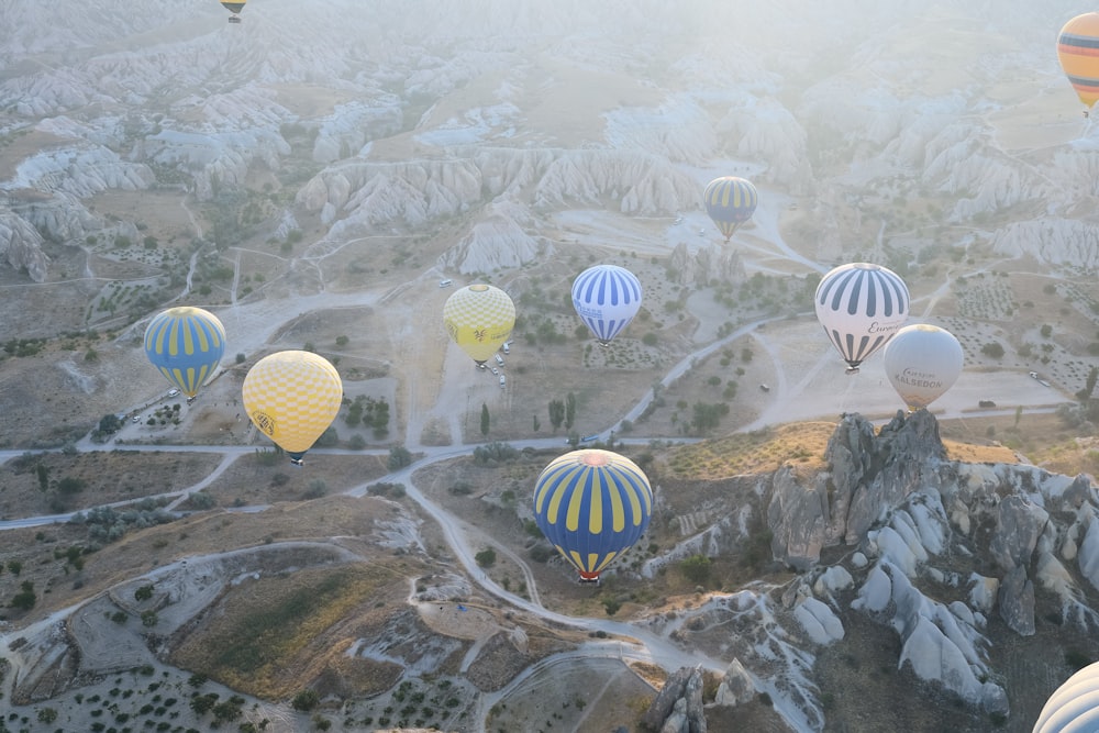 a group of hot air balloons flying over a valley