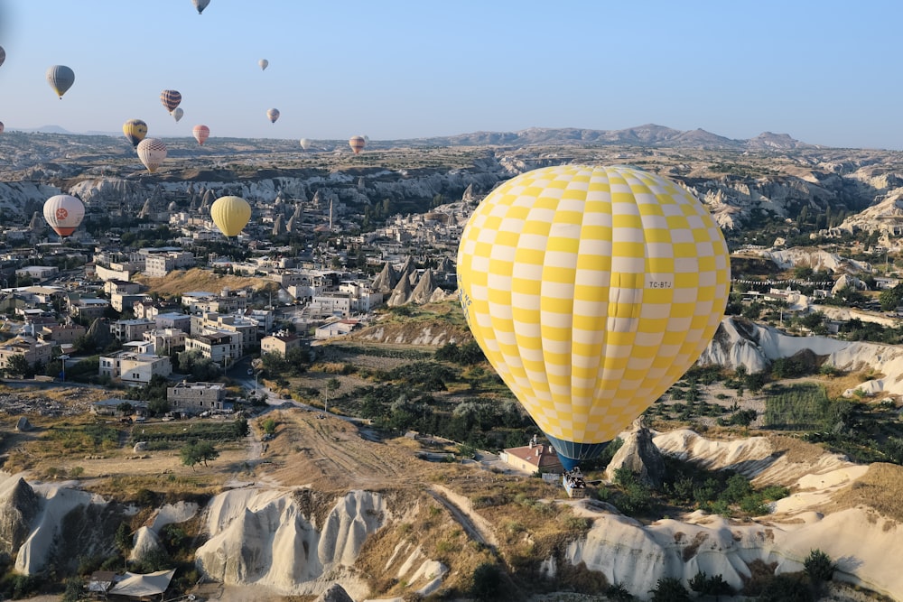 eine Gruppe von Heißluftballons, die über eine Stadt fliegen