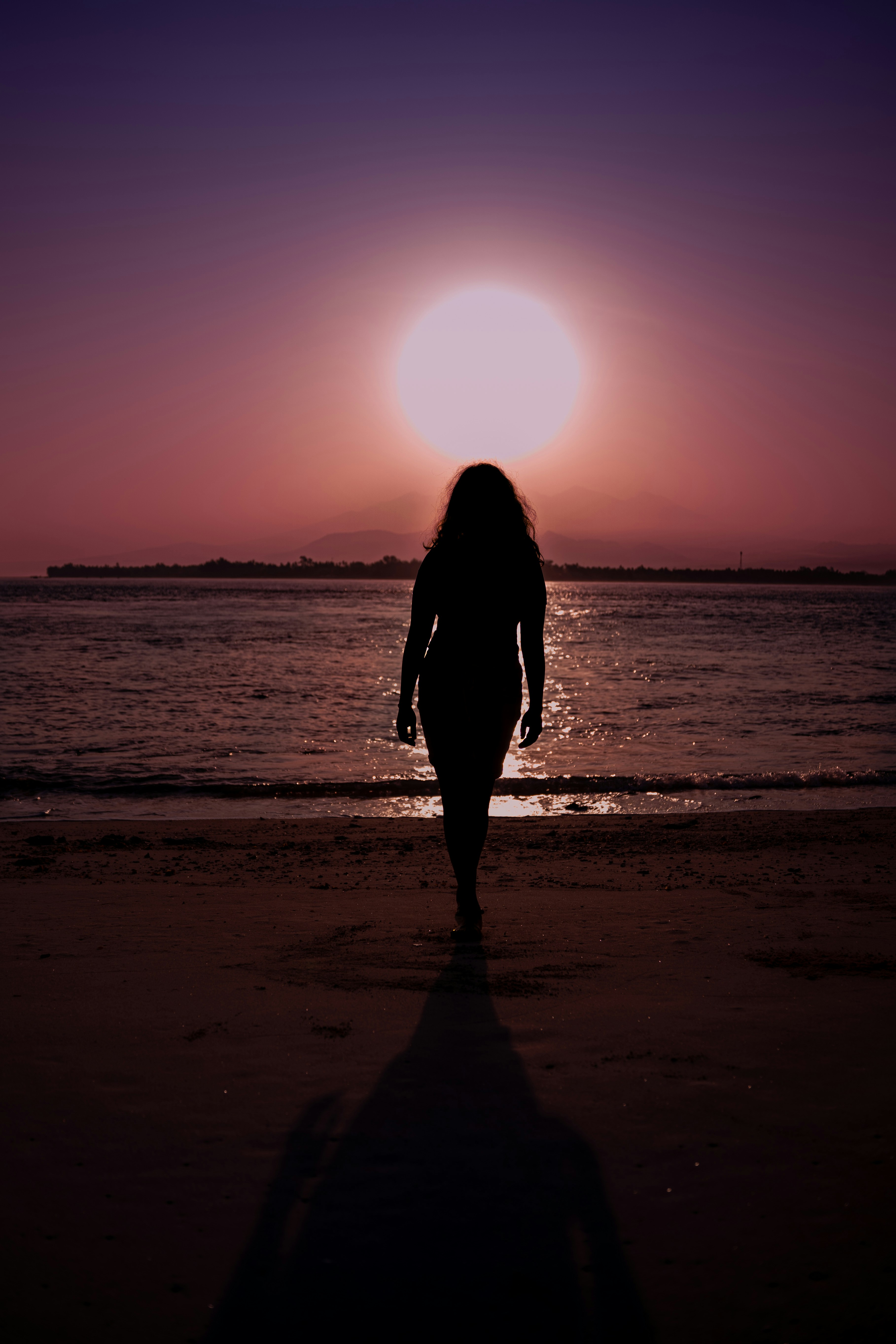 A silhouette of a woman walking on a beach at sunset photo – Free Woman ...