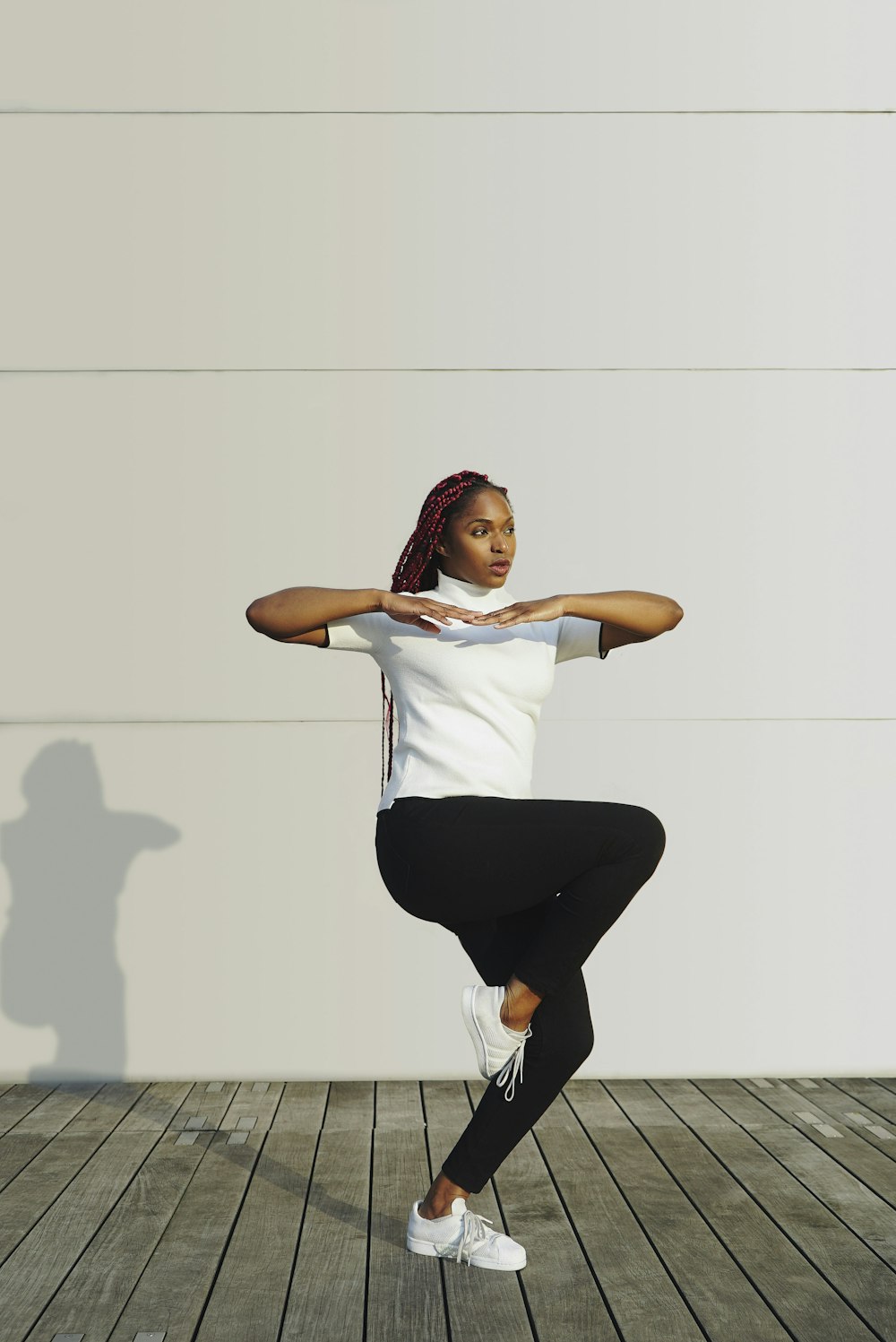 a woman doing a yoga pose on a wooden floor