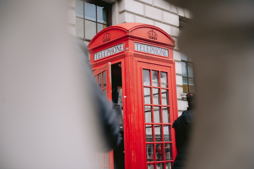 a red telephone booth in front of a building